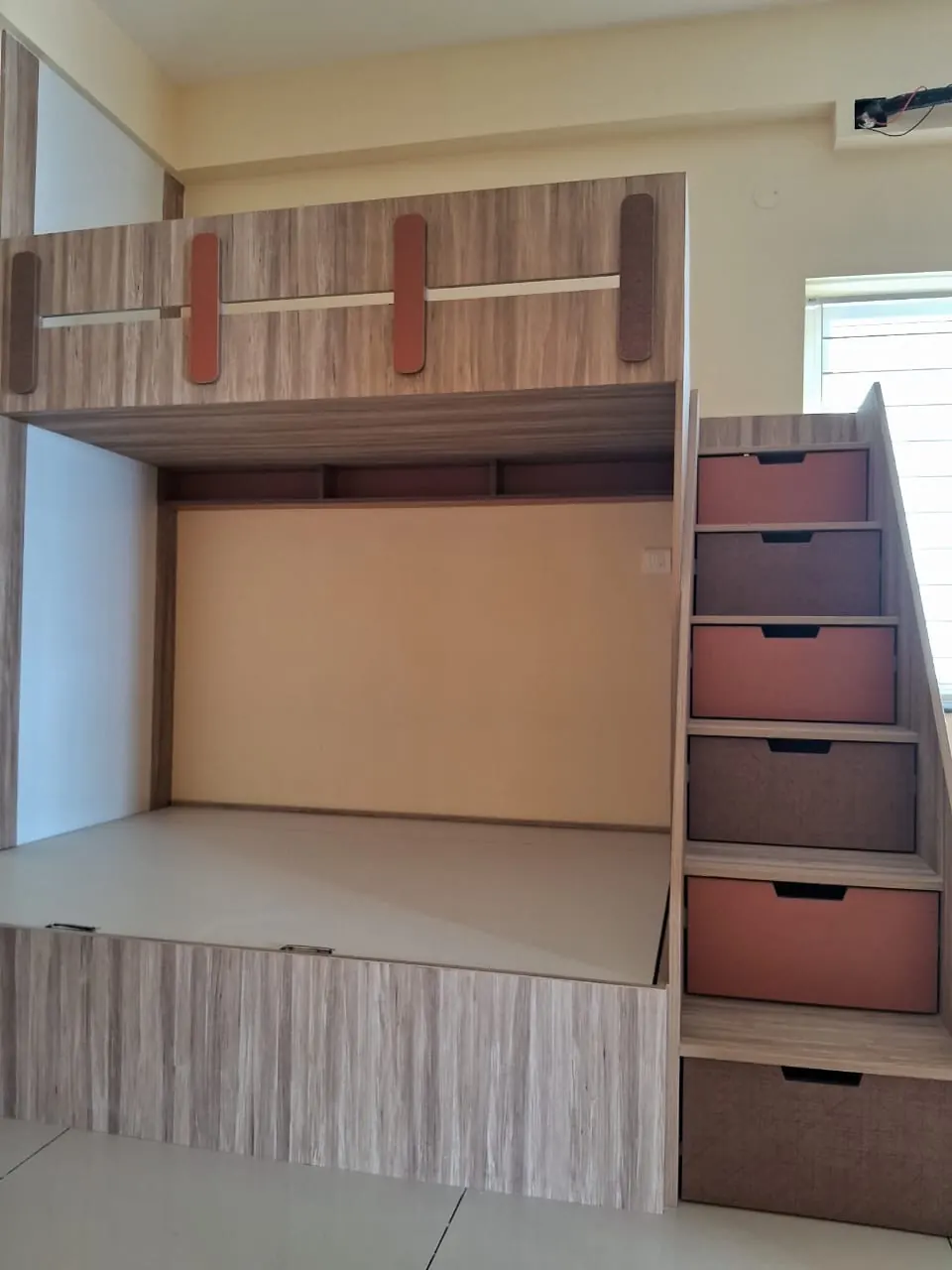 Raised bed platform with a staircase of storage drawers