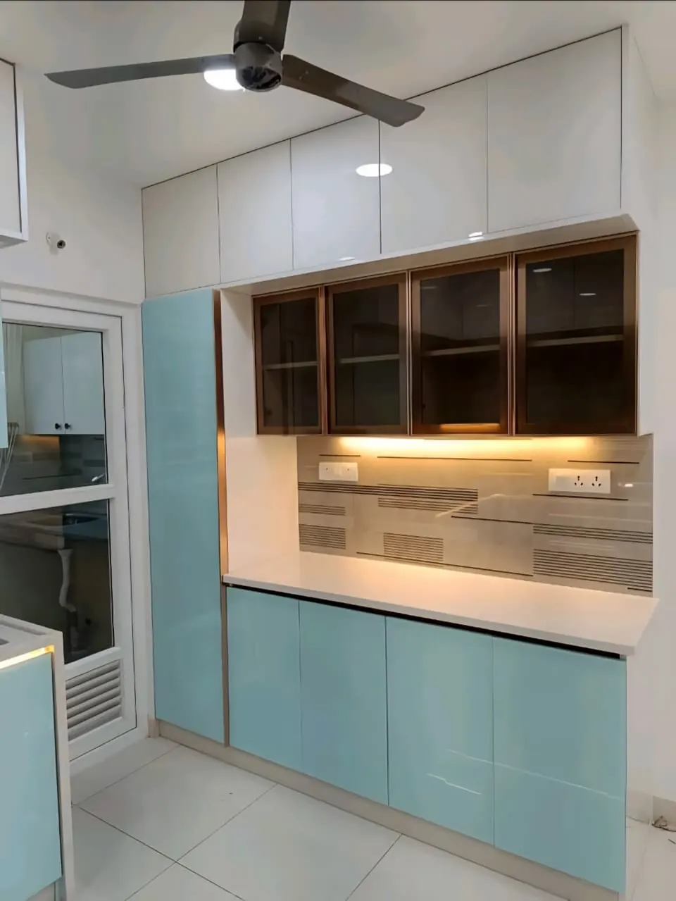 Crockery unit with glass-front cabinets, a lit open niche and pale blue lower shutters