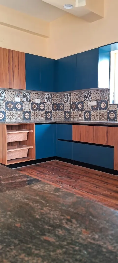 Kitchen with blue and wood-finish units under a patterned tile backsplash