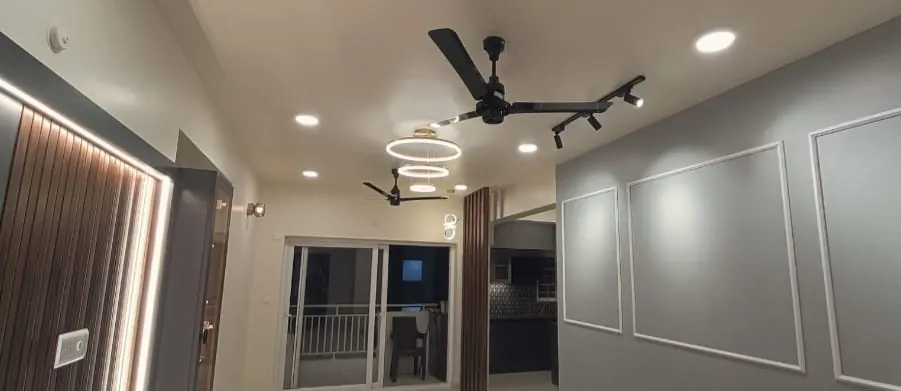 Living room with a false ceiling, LED strip lights, wall moulding and a fluted wood panel