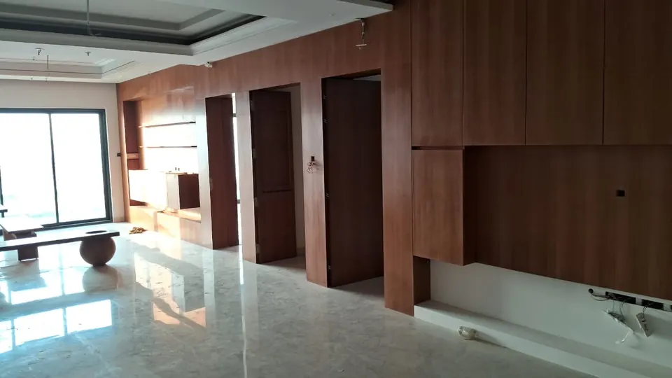 Large living room with wood-finish wall panelling and a built-in TV wall