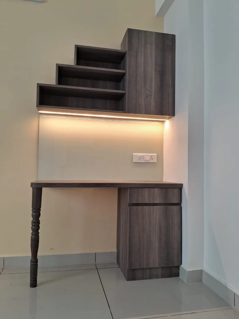 Wall-mounted study desk with stepped shelves and lighting under the shelf
