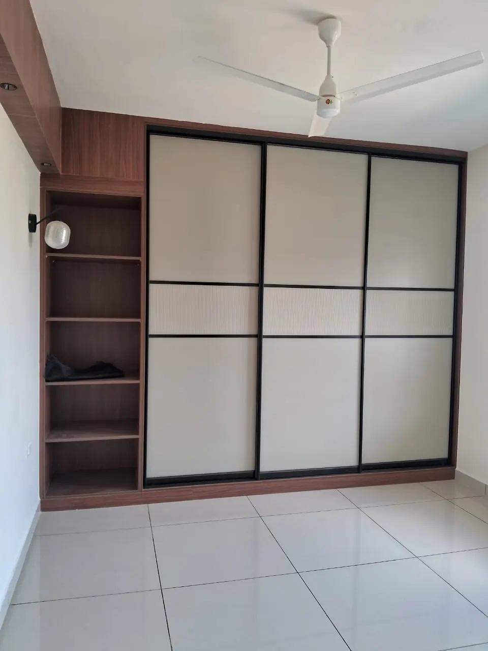Sliding-door wardrobe with pale panels and an open shelf unit at one side
