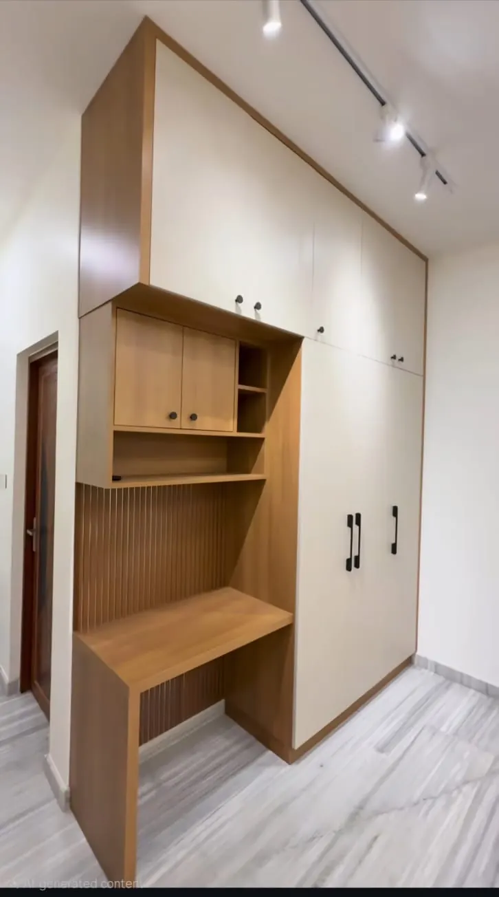 Floor-to-ceiling white wardrobe beside a wood-finish study desk with open shelves